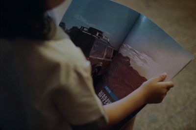 a person holding a book with a picture of a car on it