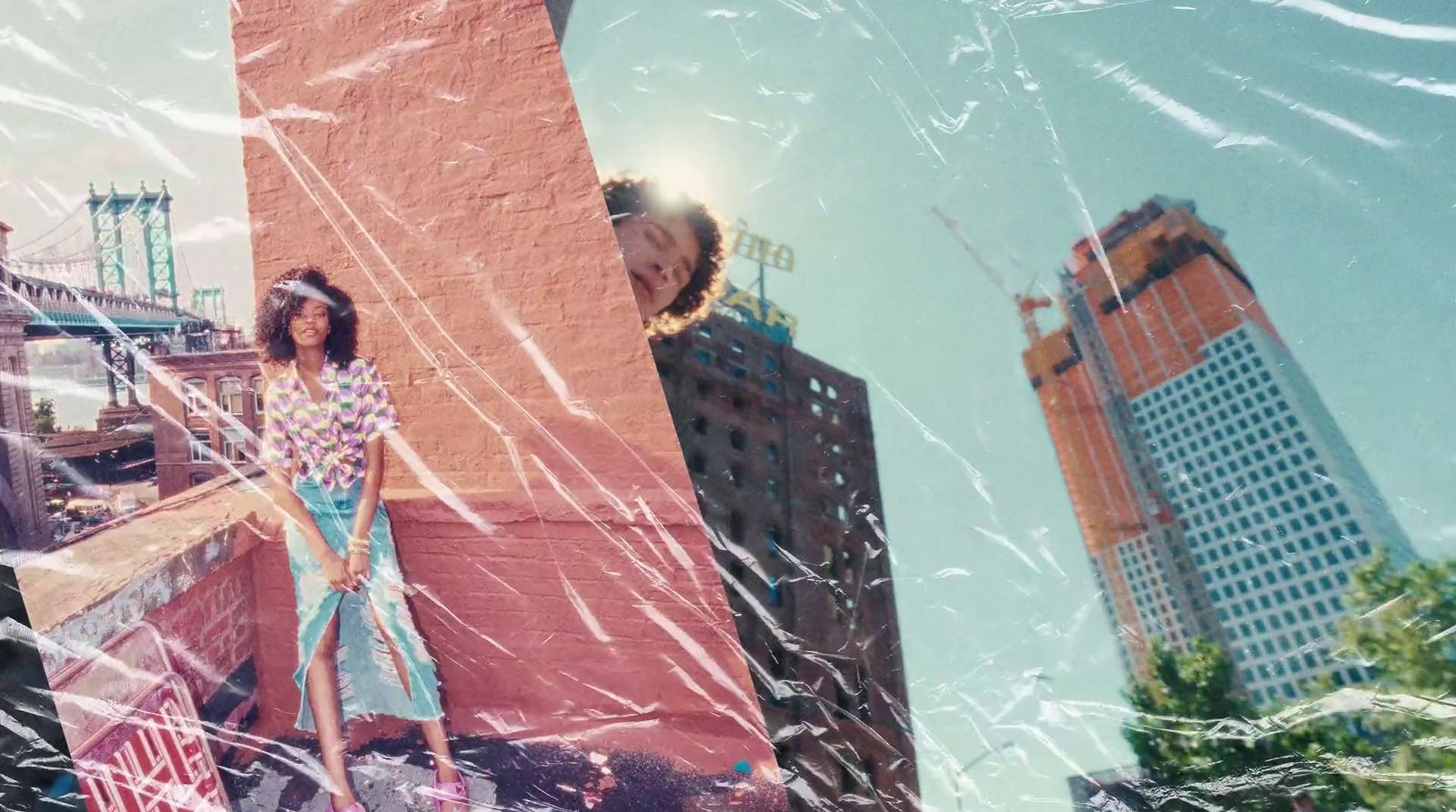 a woman standing on top of a building next to tall buildings