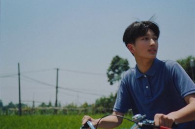 a young man riding a bike in a grassy field