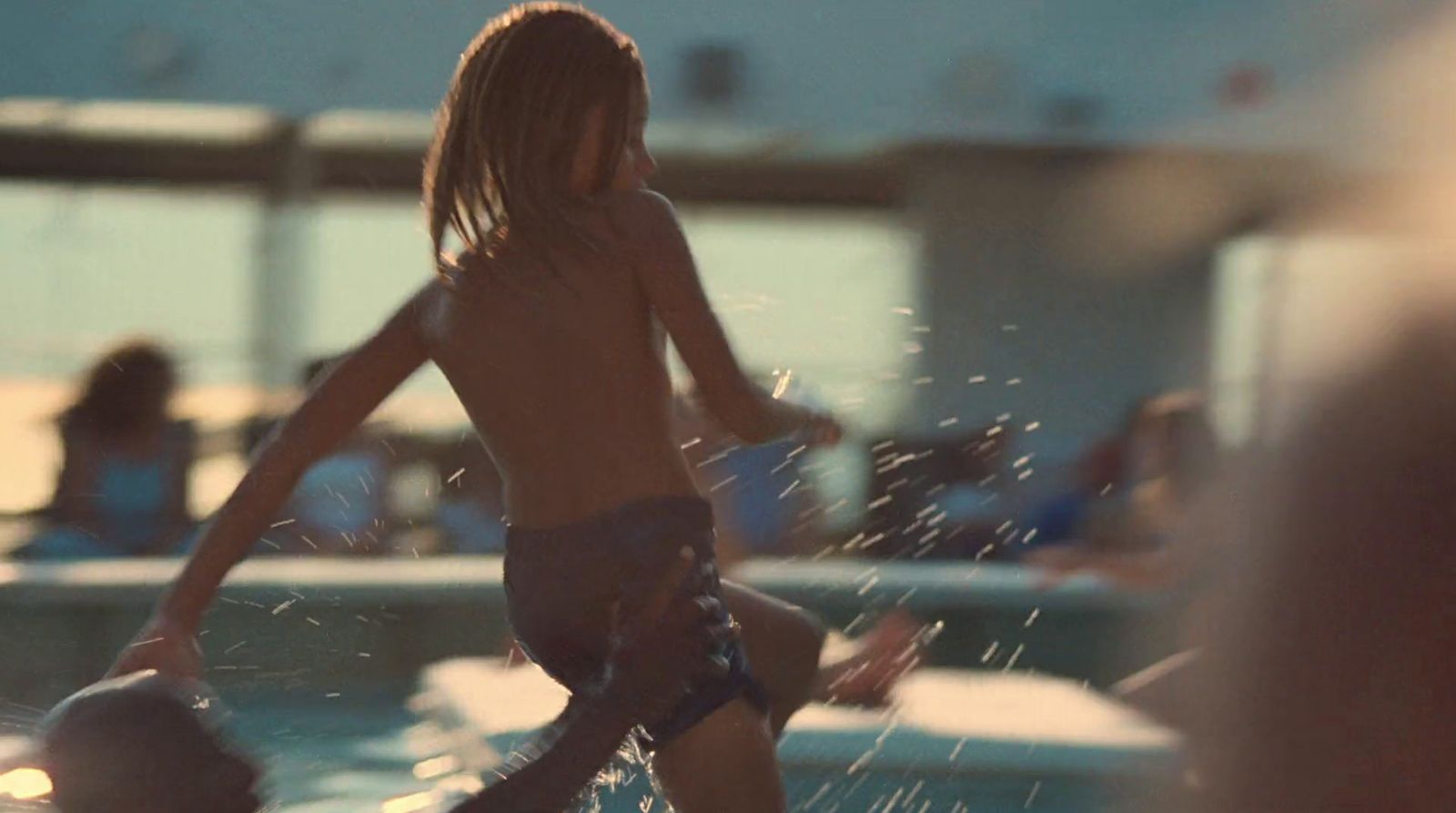 a young boy standing on a surfboard in the water