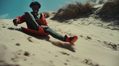 a man sitting on top of a sandy hill