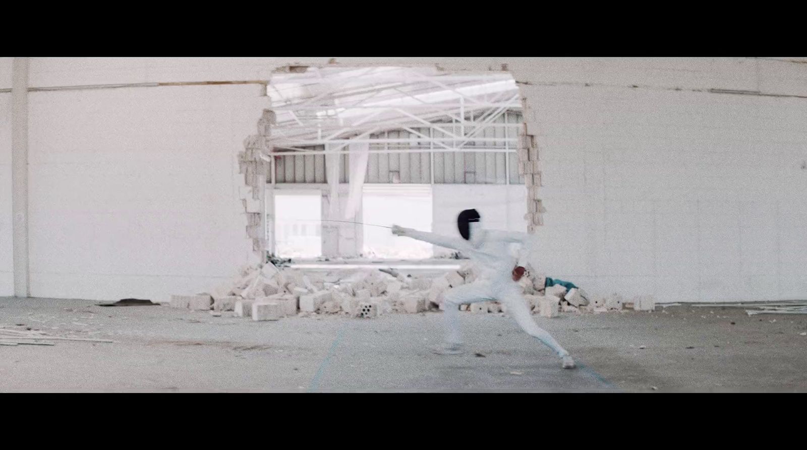 a woman in a white suit is kicking a soccer ball