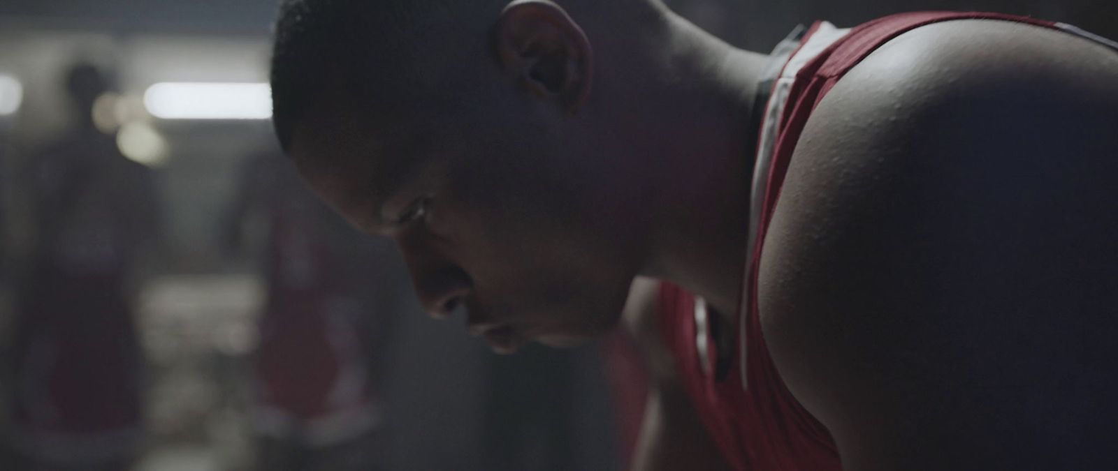 a man in a red tank top looking down