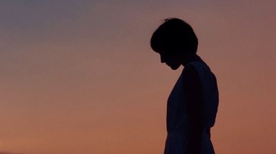 a silhouette of a person standing in front of a sunset