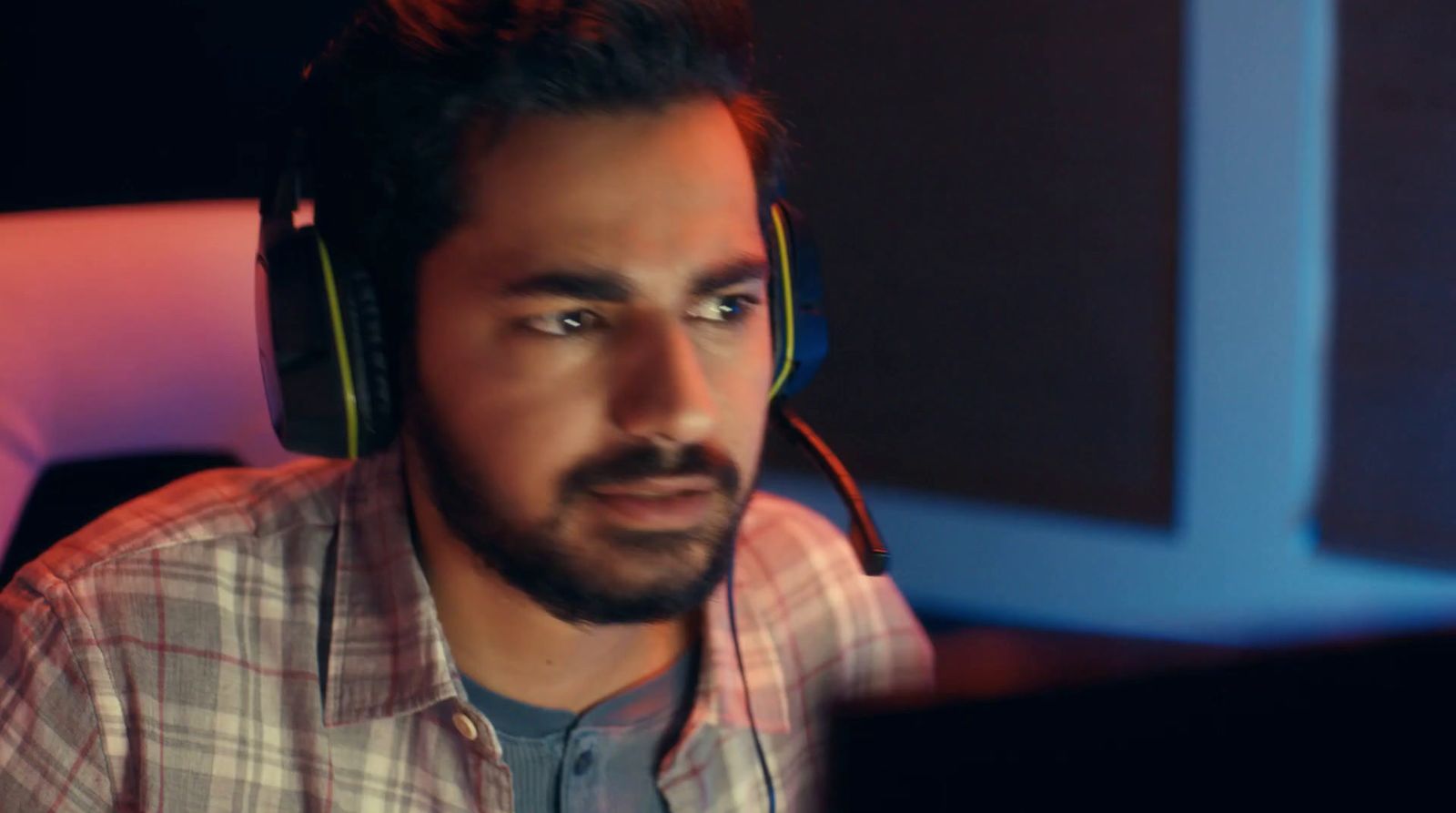 a man wearing headphones sitting in front of a computer