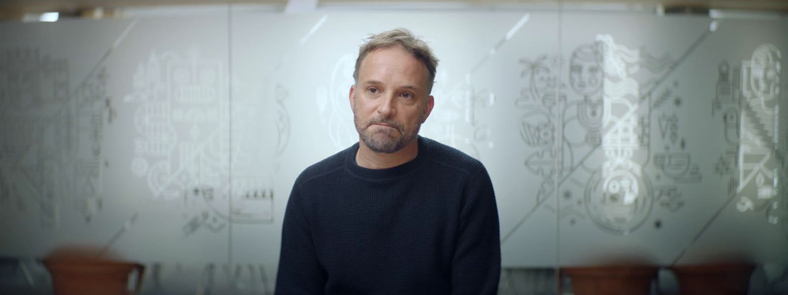 a man standing in front of a glass wall