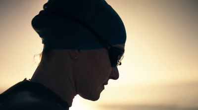 a man wearing a hat and sunglasses looking at the sun