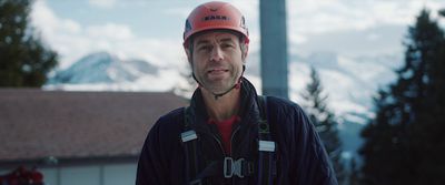 a man wearing a helmet standing in front of a building