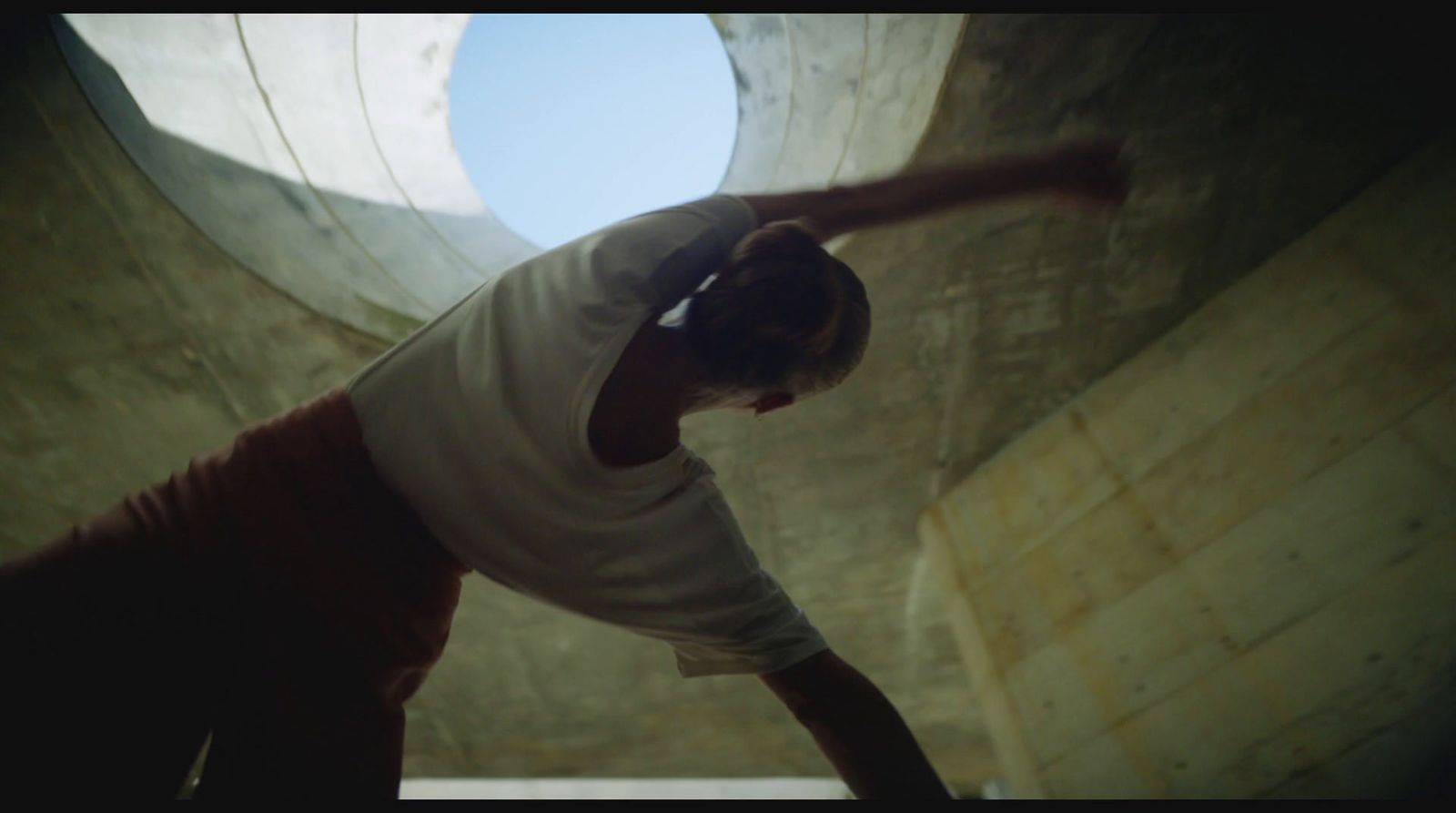 a man in white shirt doing a trick on a skateboard