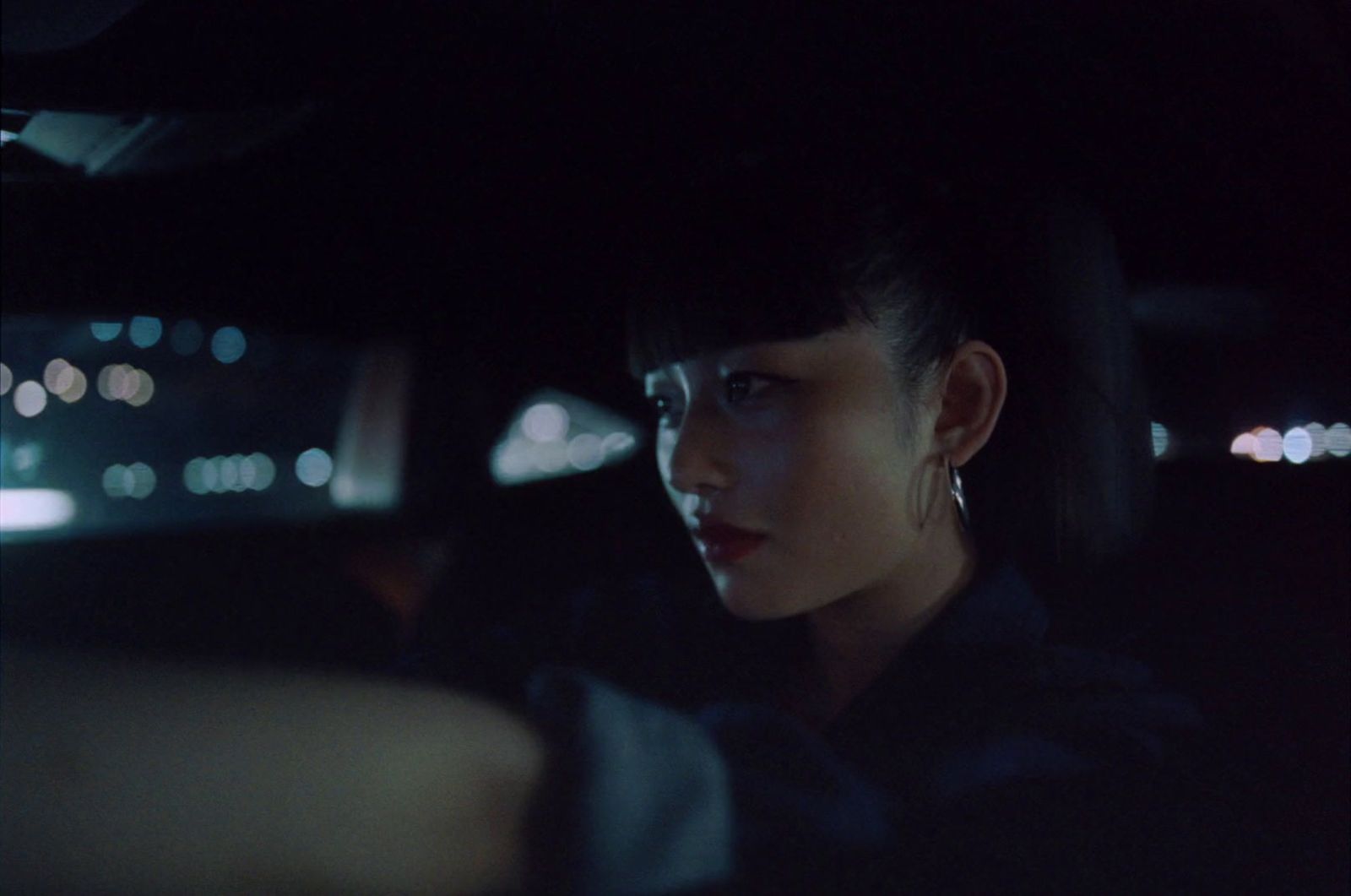 a woman sitting in the passenger seat of a car at night