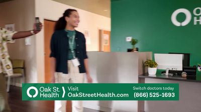 a man and a woman standing in front of a green sign