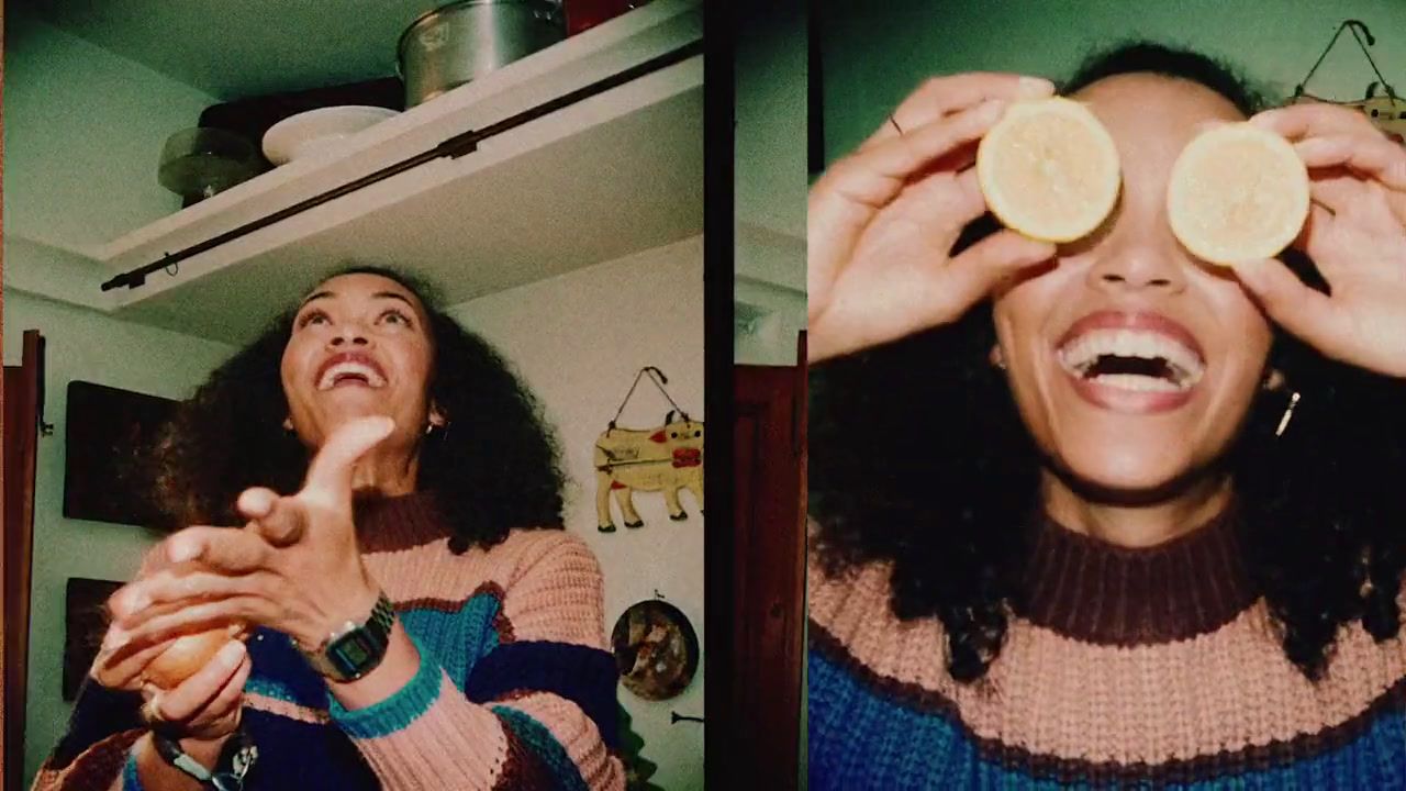 a woman holding two slices of fruit up to her eyes