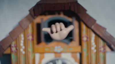 a close up of a cuckoo clock with a hand coming out of it