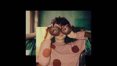 a woman holding two donuts up to her eyes