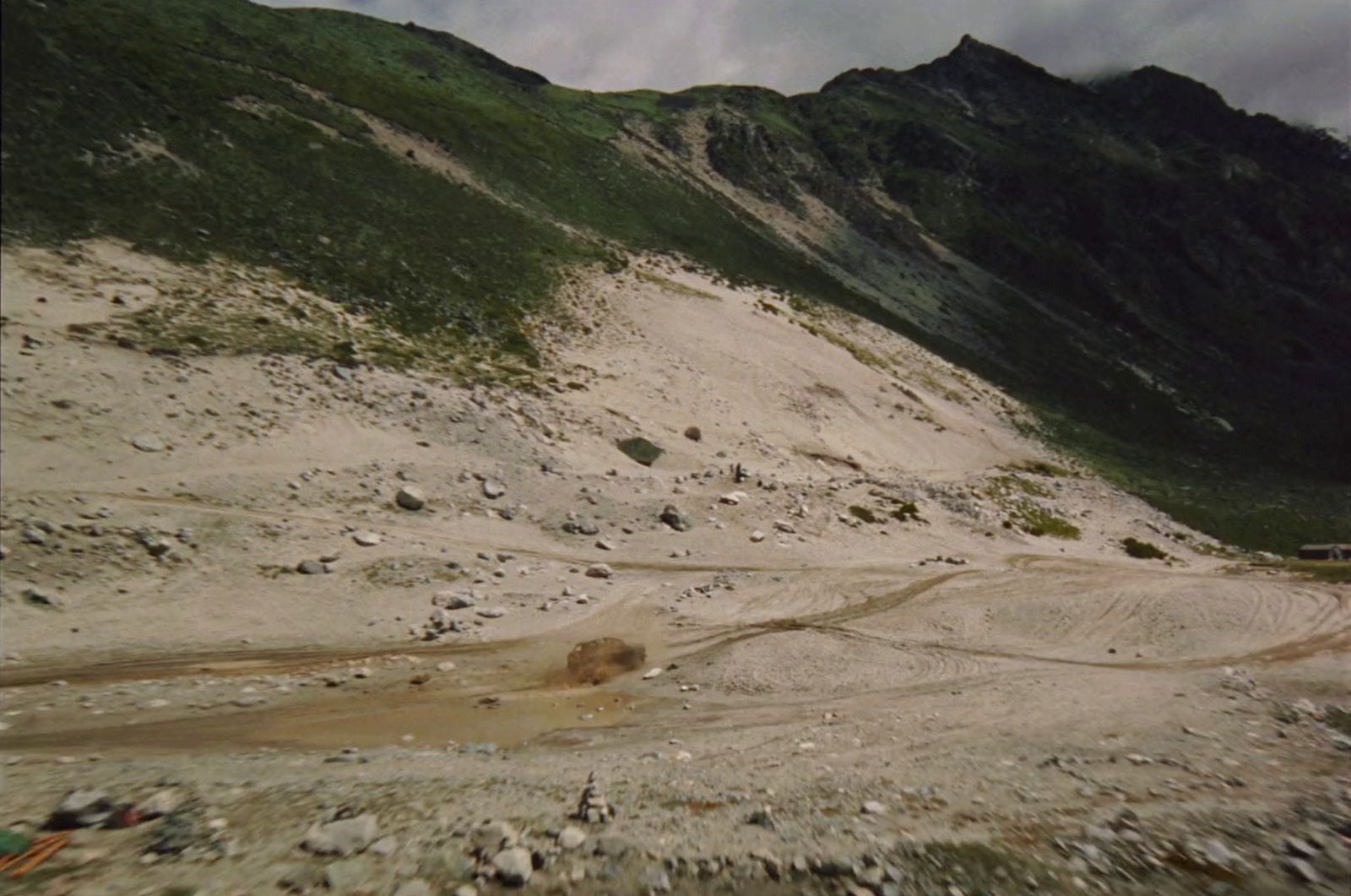 a dirt field with a mountain in the background