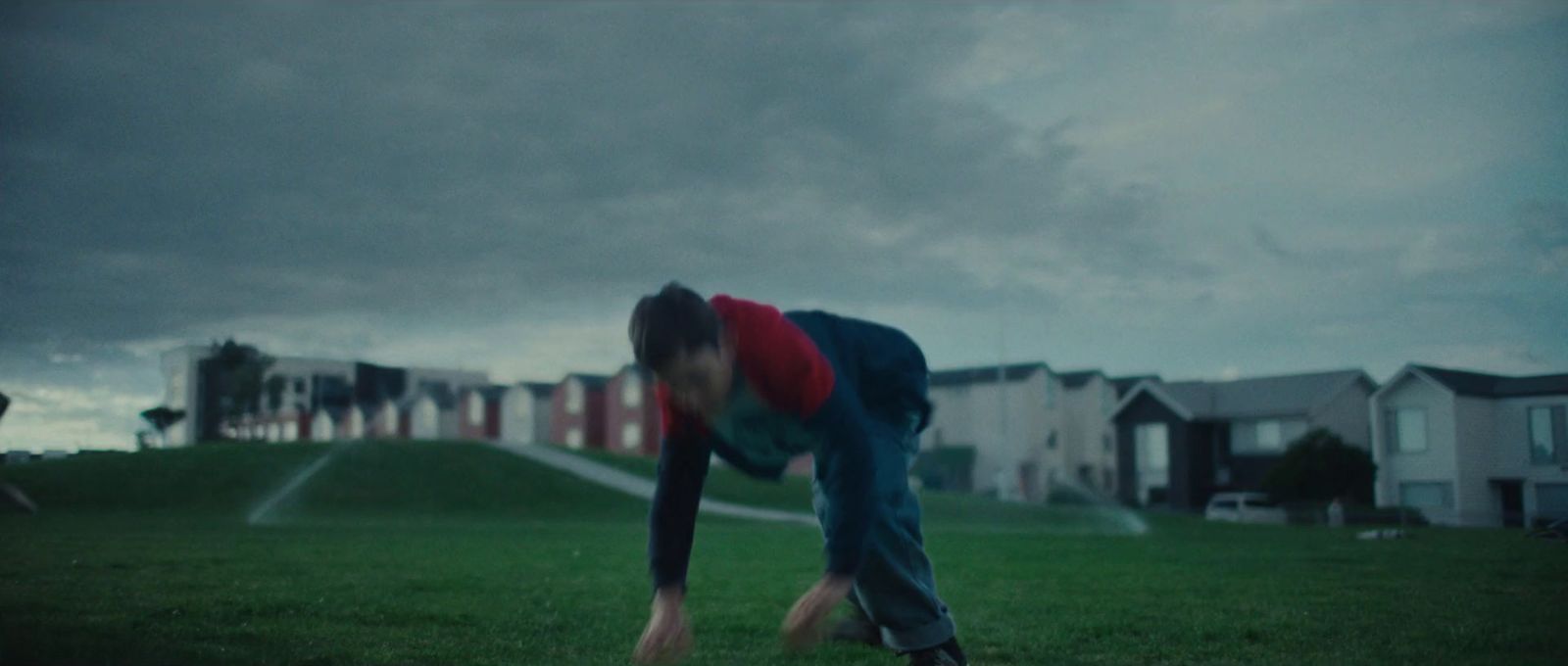 a person bending over in a grassy field