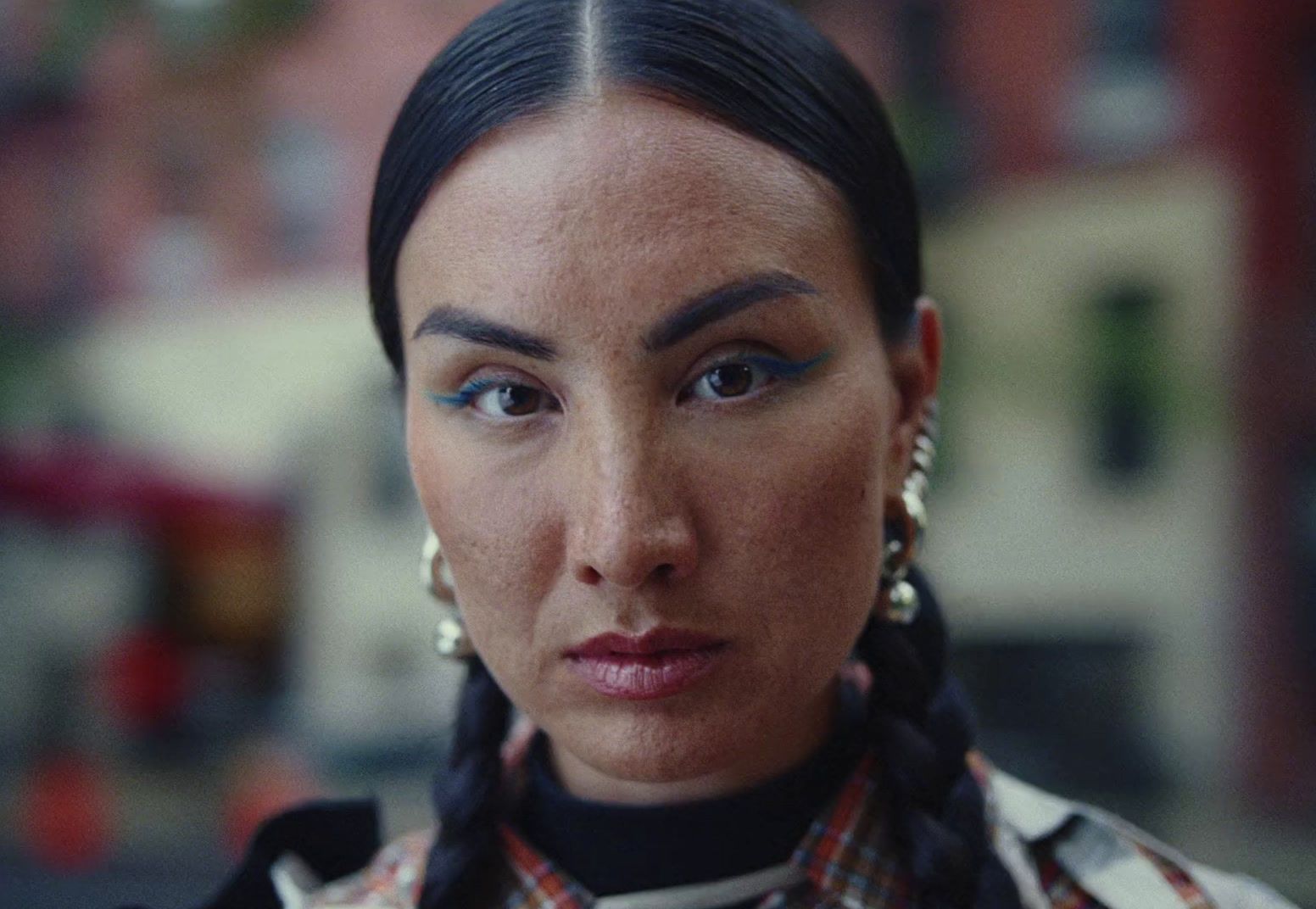 a close up of a person wearing a necklace and earrings