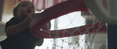 a young boy is playing with a basketball hoop