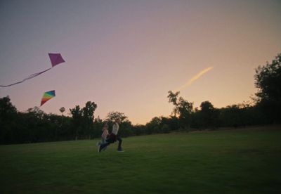 a person in a field flying a kite