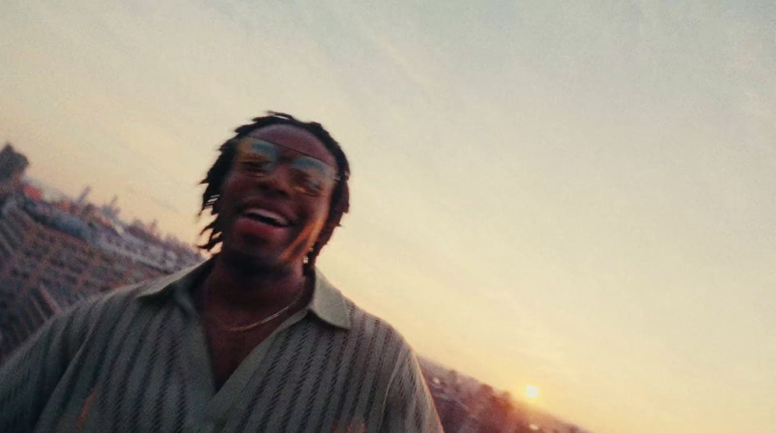 a man with dreadlocks standing in front of a building