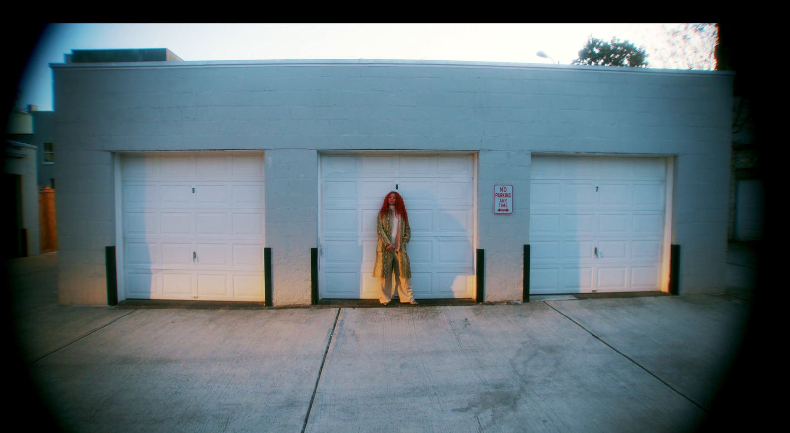 a woman standing in front of three garage doors