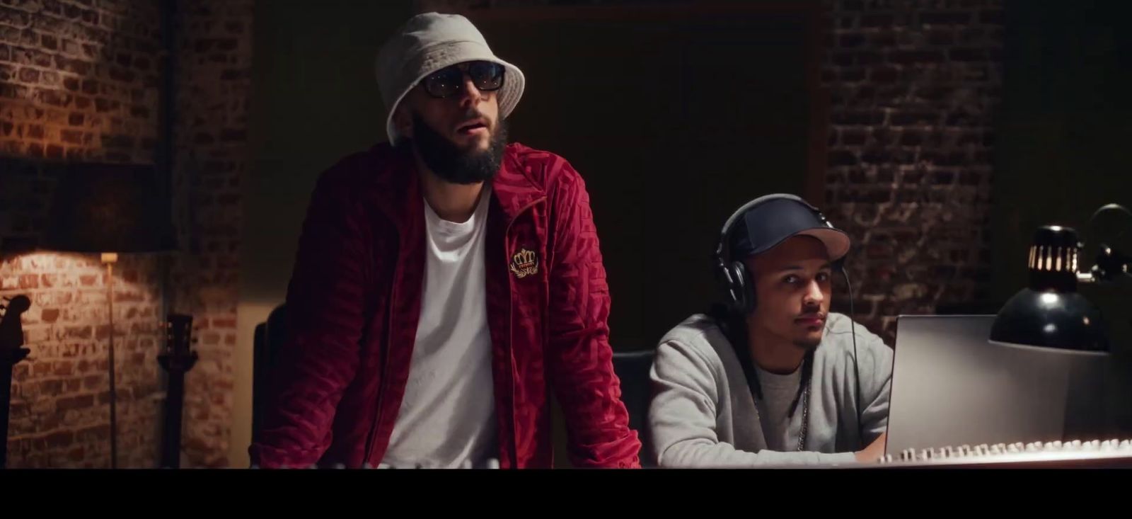 a couple of men standing next to each other in front of a computer