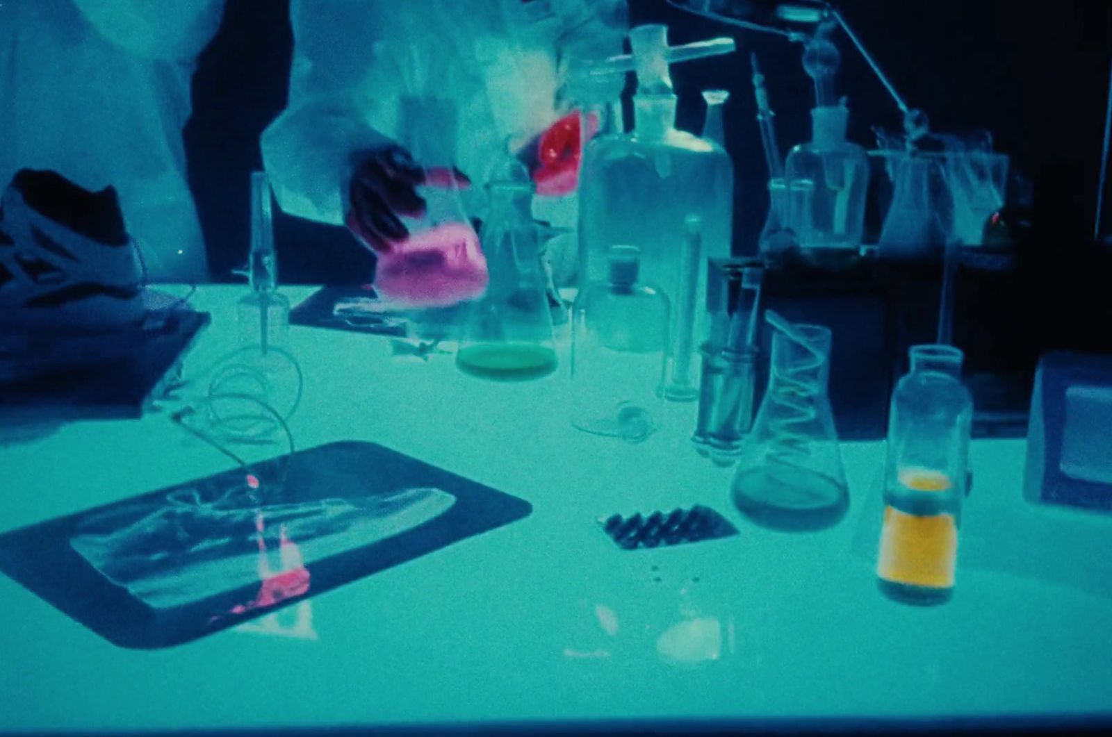 a person in a lab coat pouring liquid into a beakle