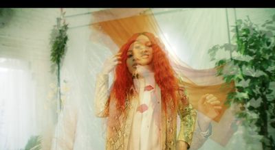 a woman with long red hair standing in front of a curtain