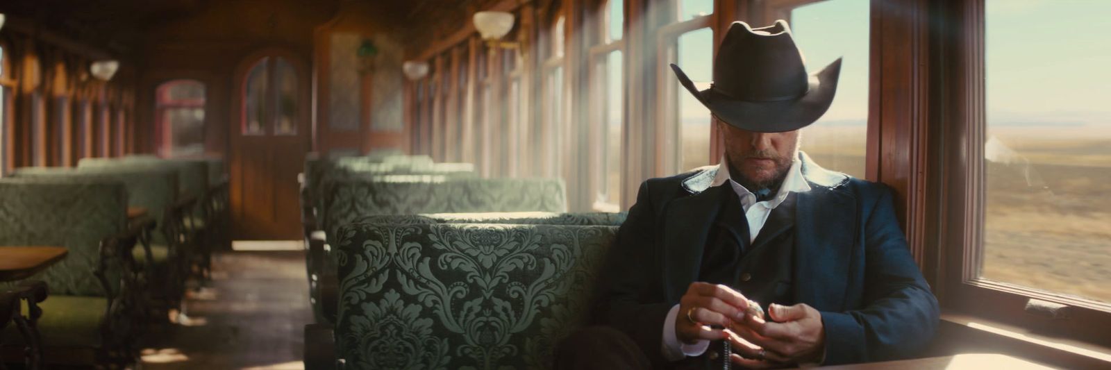 a man in a cowboy hat sitting on a train