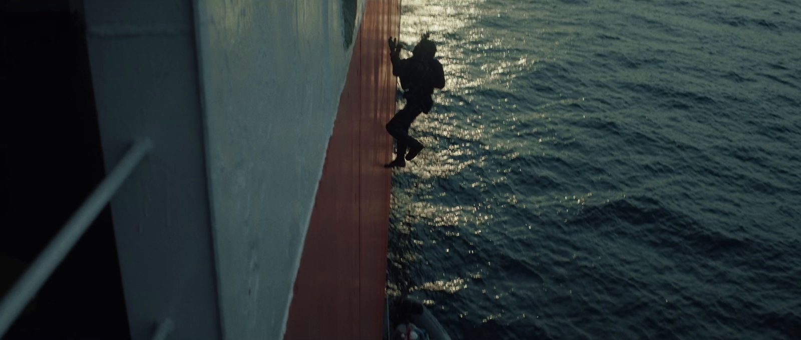 a person walking on the side of a boat in the water