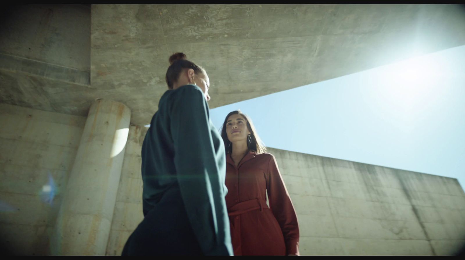 a man and a woman standing under a bridge