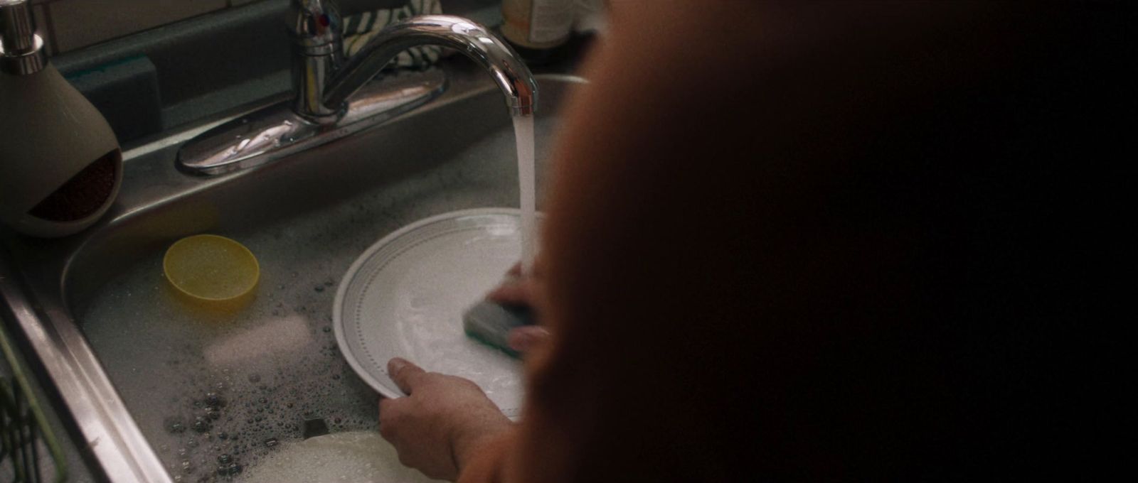 a person is washing dishes in a sink