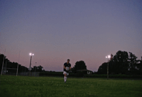 a man standing on top of a lush green field