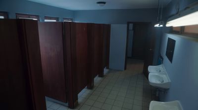 a public restroom with stalls, sinks and urinals