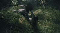 a person laying on the ground in the grass