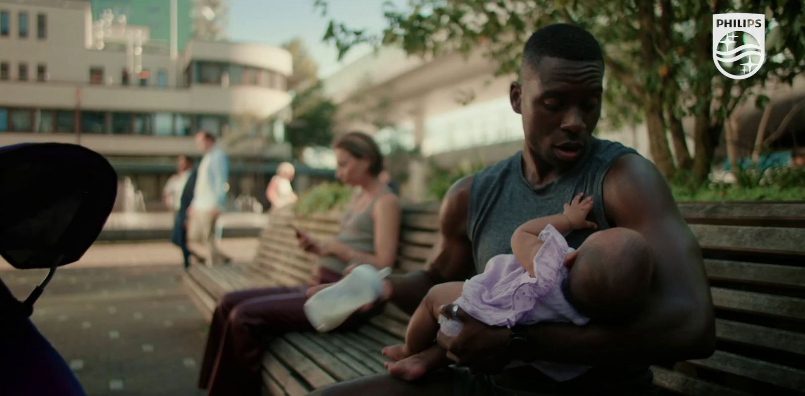 a man holding a baby while sitting on a bench