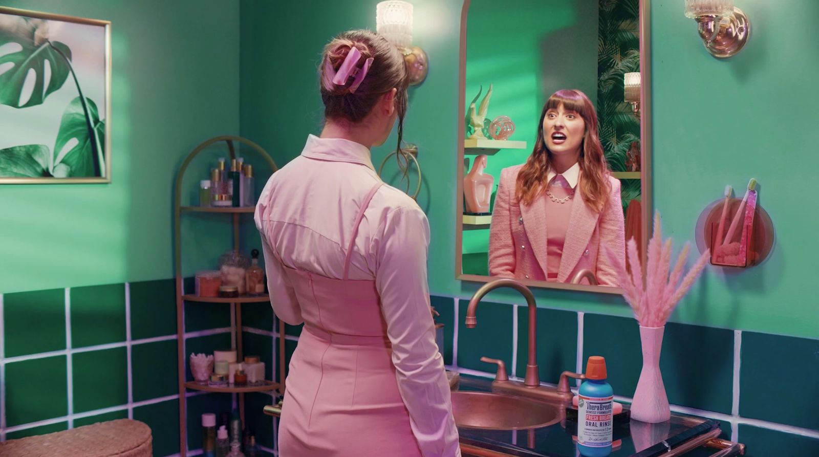 a woman standing in front of a bathroom mirror