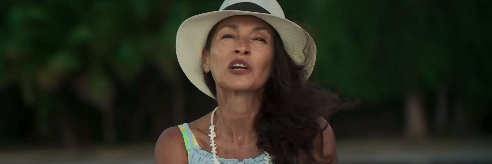 a woman wearing a white hat and a blue dress