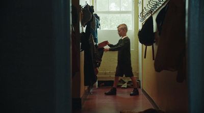 a man standing in a hallway next to a window