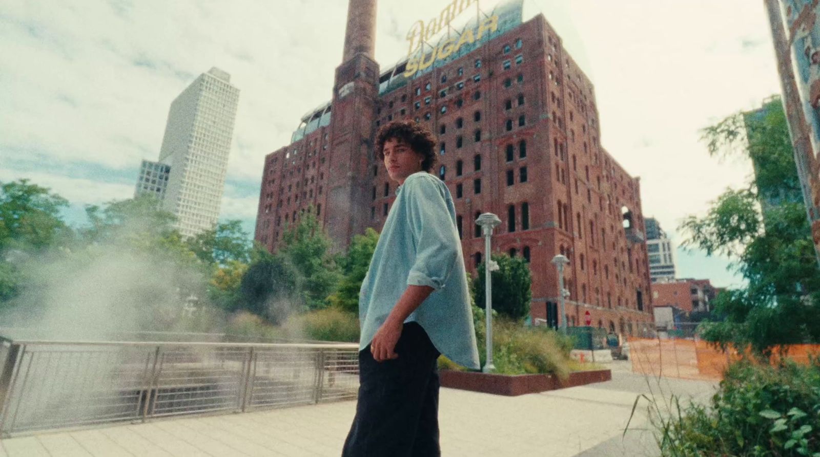 a woman standing on a sidewalk in front of a tall building