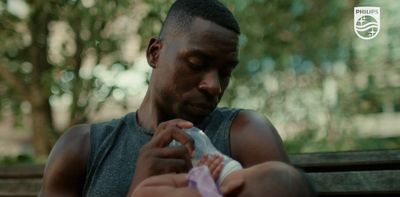 a man feeding a baby with a bottle