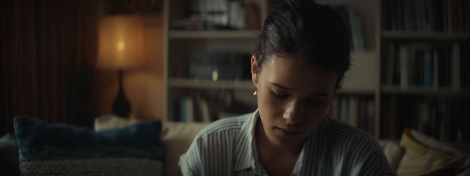 a woman sitting on a couch looking at a cell phone