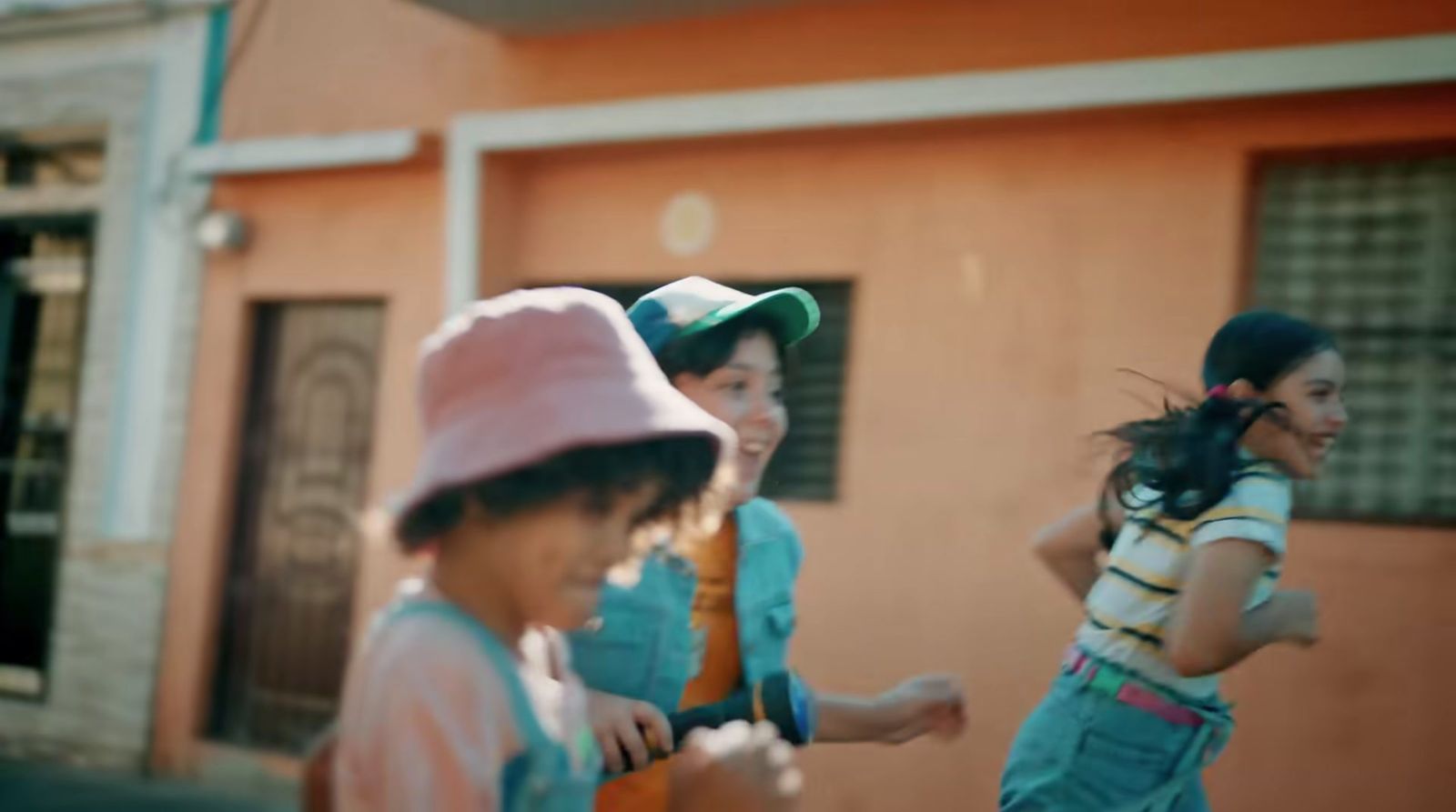 a group of young children running down a street