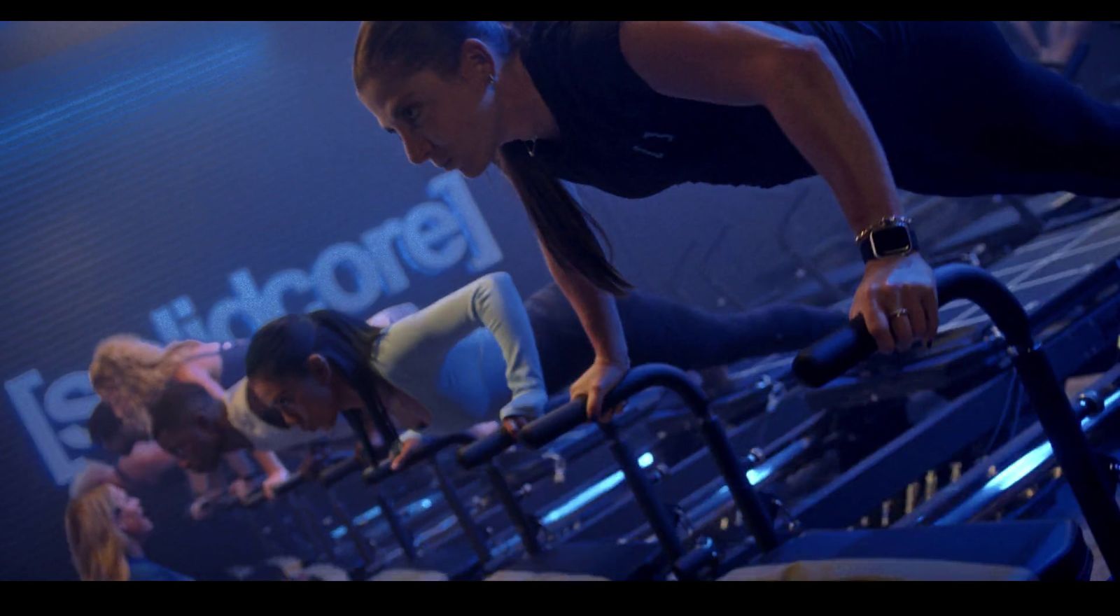 a group of women doing push ups in a gym