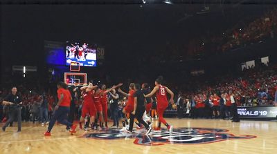 a group of people standing on top of a basketball court