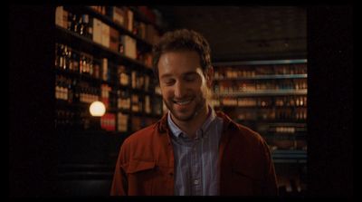 a man standing in front of a book shelf