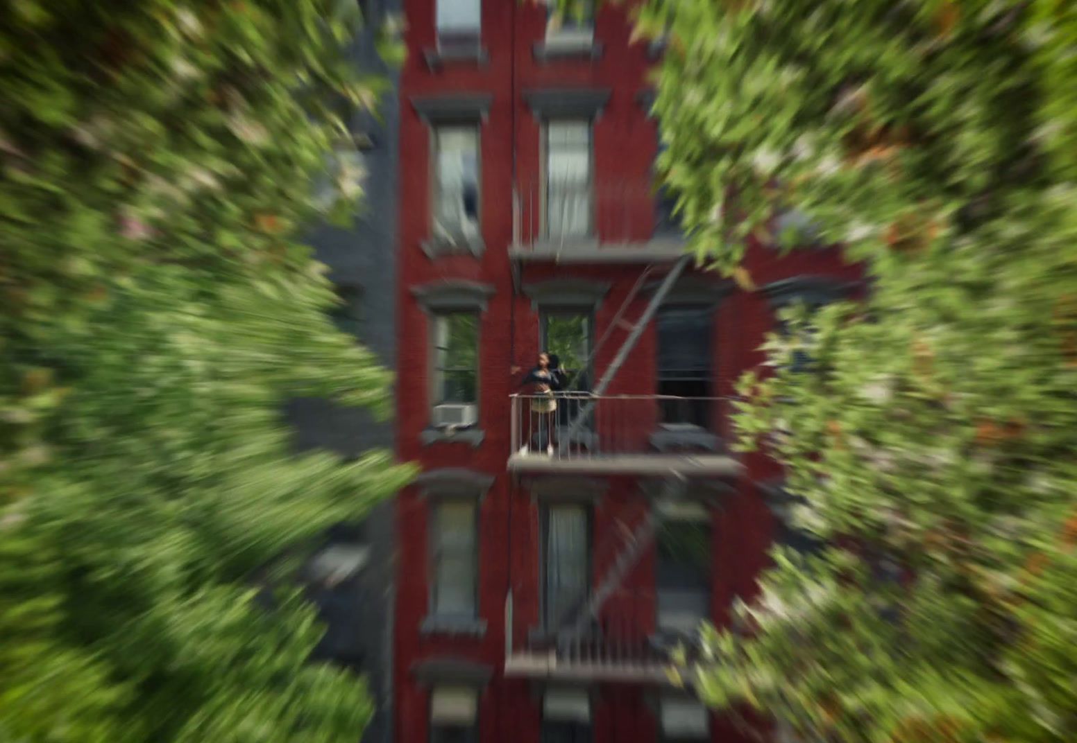 a tall red building with a man standing on a balcony