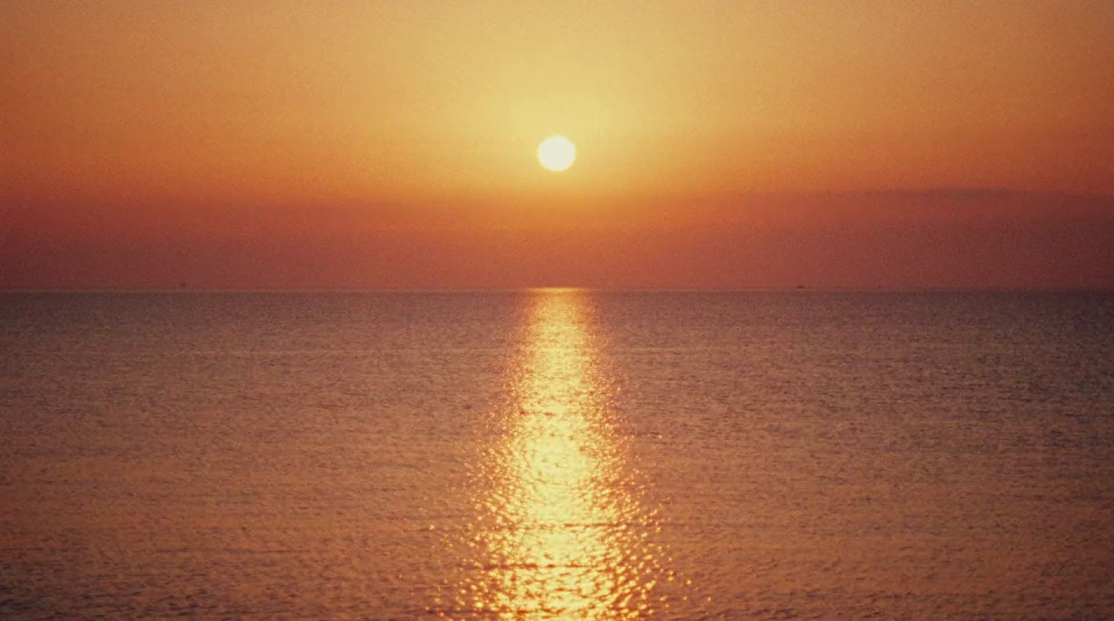 the sun is setting over the ocean on a clear day