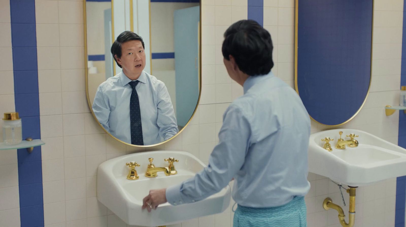 a man standing in front of a mirror in a bathroom