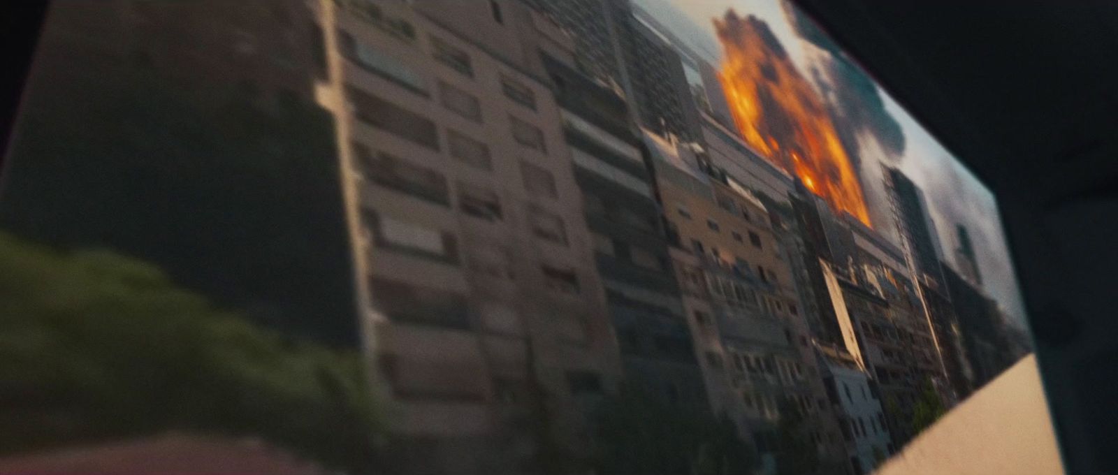 a picture of a building with a fire in the background